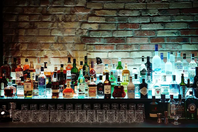 Finished bar with backlit bottle shelf against a brick wall