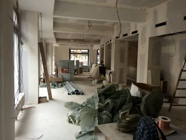 Future lounge area in shell state with building materials and drywall