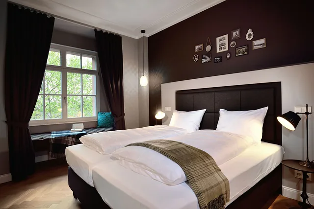 Finished guest room with double bed, dark feature wall and curtains